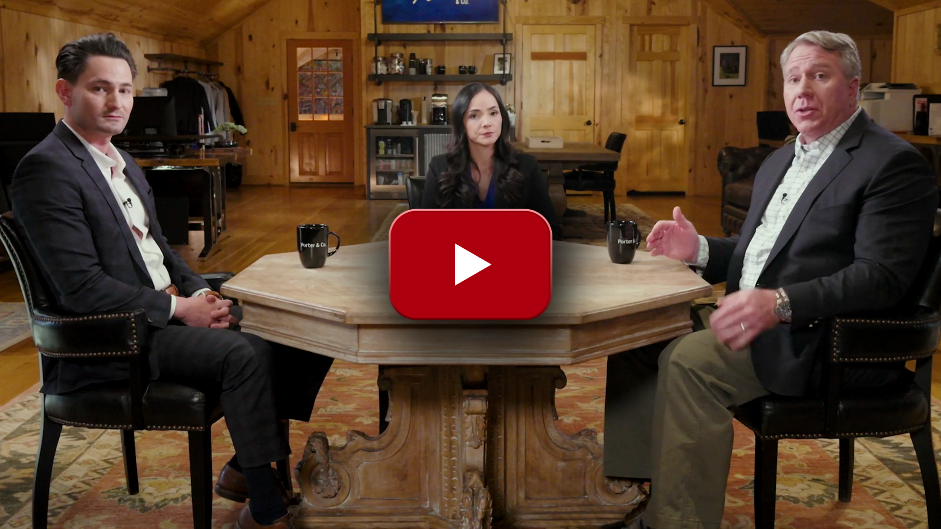 Porter Stansberry sitting at a table with Luke Lango and an unnamed woman, likely a reporter or moderator